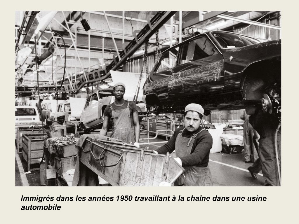 Immigrés dans les années 1950 travaillant à la chaîne dans une usine automobile