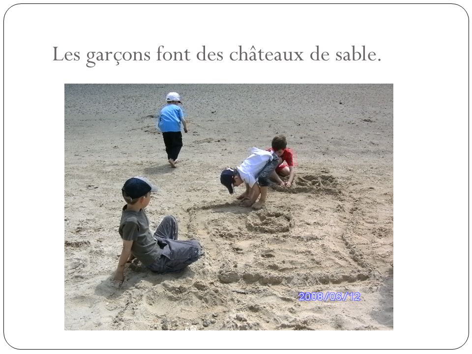 Les garçons font des châteaux de sable.